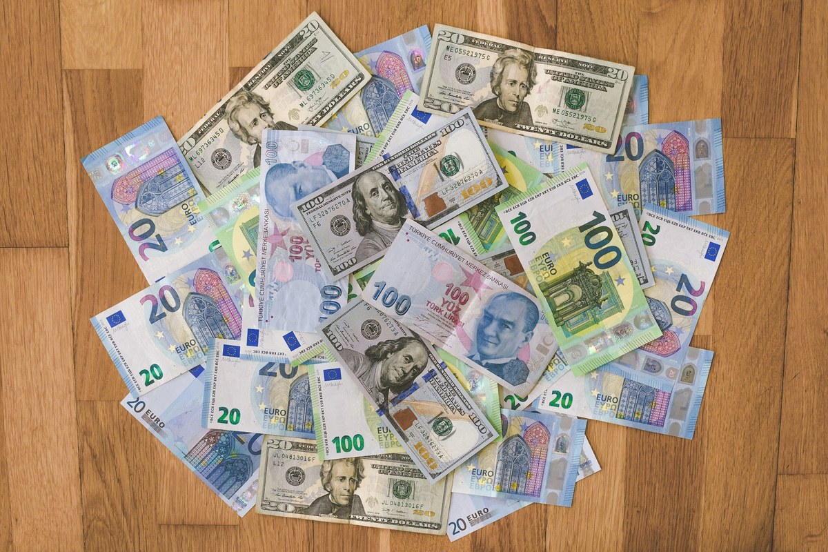 שטרות כסף ממטבעות שונים על שולחן עץ